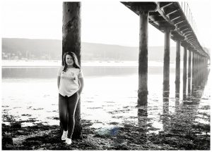 black and white teen portrait photo under lochside pier looking towards cove and kilcreggan Life in Focus Portraits teenage photography Rhu Helensburgh Garelochhead