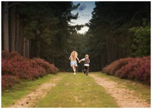 brother and sister running through forrest Life in Focus Portraits child photographer Loch Lomond and the Trossachs national park Scotland