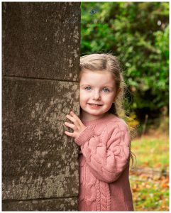 girl peeping round corner outdoor child photoshoot Life in Focus Portraits family photographer Cardross Dumbarton