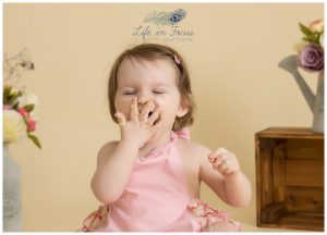 baby laughing while eating cake 1st birthday cake smash photography session Life in Focus Portraits studio childrens photographer Rhu Helensburgh