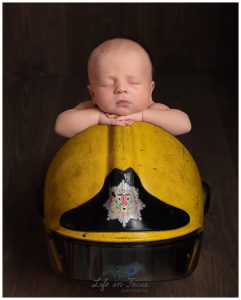 newborn baby boy on dads firefighter helmet Life in Focus Portraits newborn baby photographer Rhu Helensburgh Garelochead