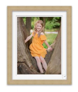 photo of young girl in tree smiling at photographer Life in Focus Portraits family outdoor photo sessions Rhu Helensburgh