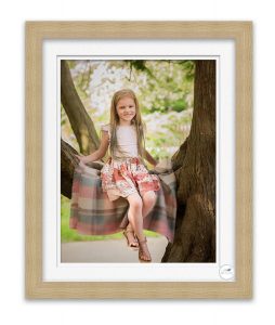 photo of young girl sitting in tree in park smiling at photographer Life in Focus Portraits family photographer Rhu Helensburgh Loch Lomond