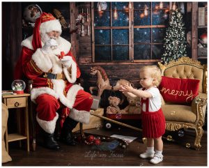 Photo of Santa blowing bubbles to little girl in red dress Christmas photoshoot at Life in Focus Portraits child photographer Helensburgh